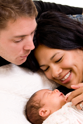 Mother and dad looking at a new born bady
